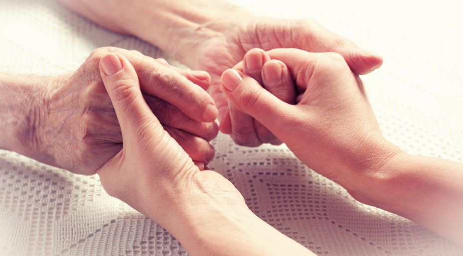 elderly person holding hands with younger person